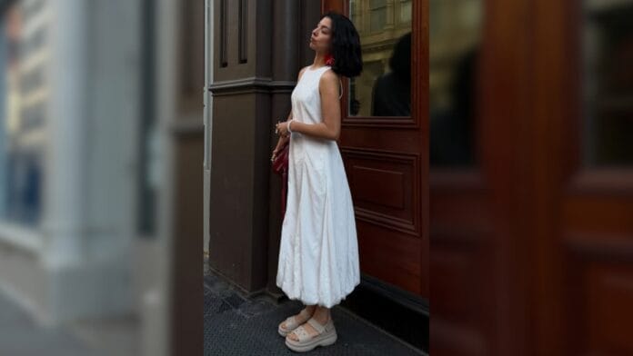 mulher com vestido branco e papete bege