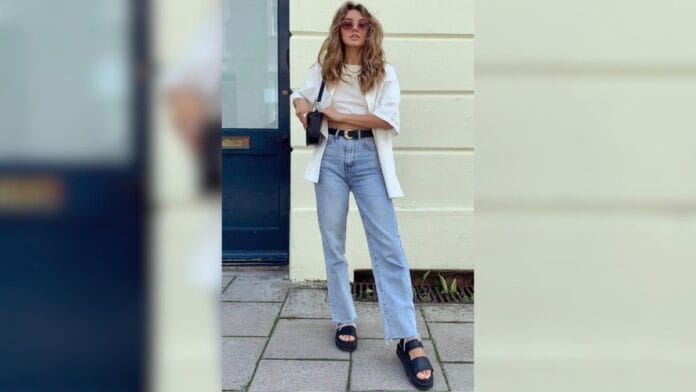 mulher com calça jeans, blusa branca e papete preta