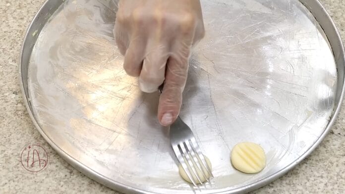 Amassando o sequinho com o garfo para fazer o detalhe no biscoito 