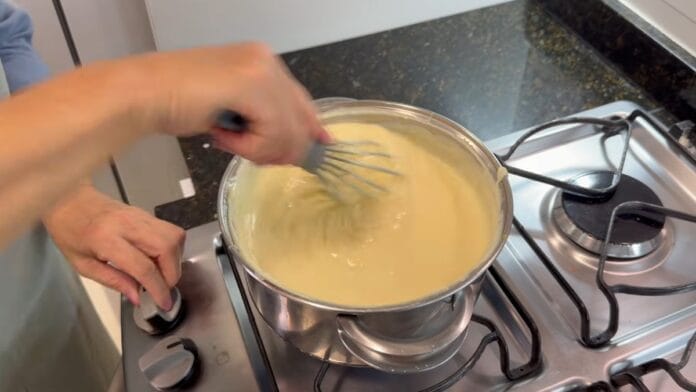 cozinheira mexendo o creme para rechear o sonho