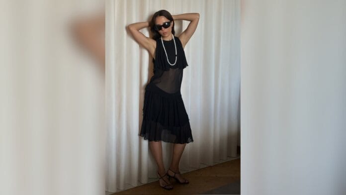 mulher com vestido preto com uma parte transparente na barriga e sapato t-strap 