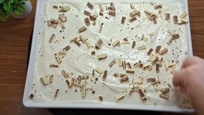 adicionando pedaços de bis sobre a torta para a  decoração