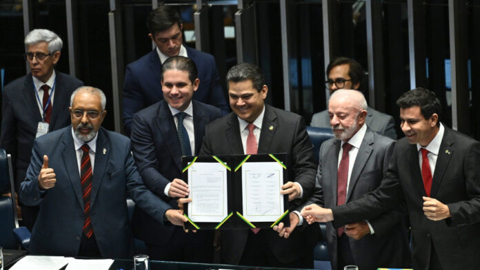 Sessão Solene - Promulgação das Emendas Constitucionais 140 e 141 de 2026
Plenário do Senado Federal durante sessão solene destinada à promulgação das Emendas Constitucionais nos. 140 e 141 de 2026, referentes, respectivamente, à Proposta de Emenda à Constituição nº 14 de 2021, que "altera os arts. 40, 198 e 201 da Constituição Federal para estabelecer o direito à aposentadoria diferenciada aos agentes comunitários de saúde e aos agentes de combate às endemias, bem como para determinar a regularização do vínculo funcional desses agentes; e dá outras providências"; e à Proposta de Emenda à Constituição nº 221 de 2019, que "altera o art. 7º da Constituição Federal para reduzir a duração máxima semanal do trabalho e prever 2 (dois) dias de repouso semanal remunerado, sem qualquer redução salarial".
Mesa:
senador Paulo Paim (PT-RS);
presidente da Câmara dos Deputados, deputado Hugo Motta (Republicanos-PB);
presidente do Senado Federal, senador Davi Alcolumbre (União-AP);
presidente da República Luiz Inácio Lula da Silva;
1º secretário da Mesa do Congresso Nacional, deputado Carlos Veras (PT-PE).