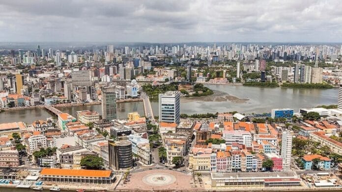 Fotografia aérea panorâmica da região central do Recife, mostrando as pontes e o horizonte urbano, representando a apuração para o Senado por Pernambuco nas Eleições 2026