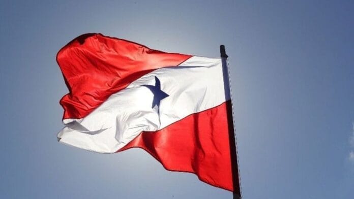 Bandeira do Estado do Pará a ondular sob céu azul, com a sua faixa branca diagonal e estrela azul num fundo vermelho, representando a apuração geral das Eleições de 2026.