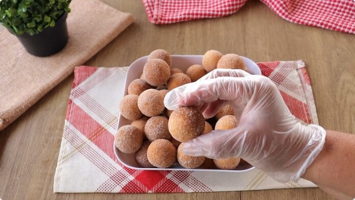 Travessa branca com bolinhos de chuva passados no açúcar e canela