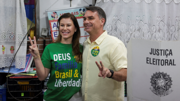 O candidato à presidência do Brasil, Flávio Bolsonaro, do Partido Liberal (PL), acompanhado de sua esposa Fernanda Bolsonaro, gesticula enquanto vota durante as eleições gerais, no Rio de Janeiro, Brasil, em 4 de outubro de 2026. REUTERS/Ricardo Moraes