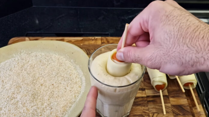 aplicando a massa em torno da salsicha