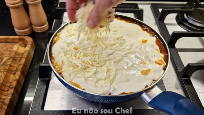 adicionando o queijo ralado na lasanha