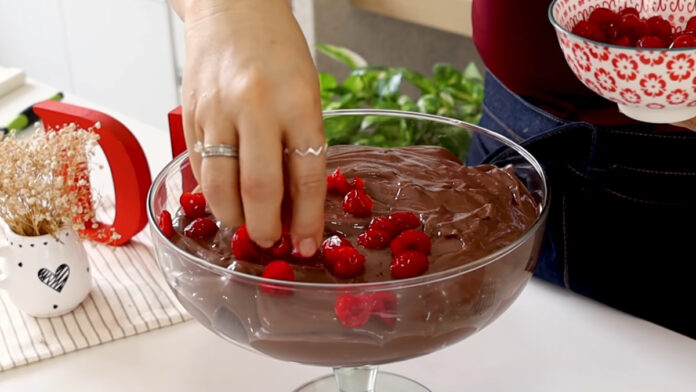 adicionando aas frutas vermelhas sobre o pavê