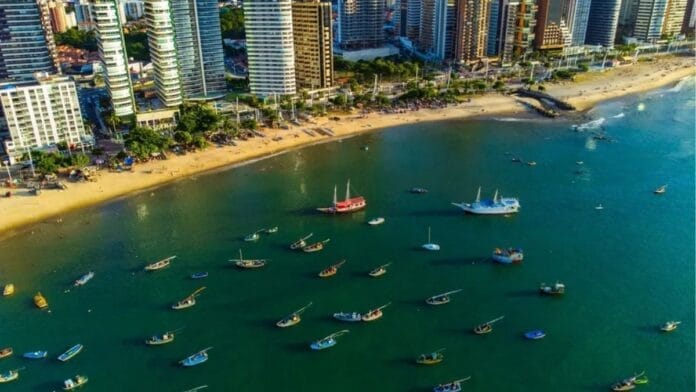 Vista aérea da orla de Fortaleza com barcos no mar e prédios na praia, ilustrando a apuração para o Senado no Ceará nas Eleições 2026