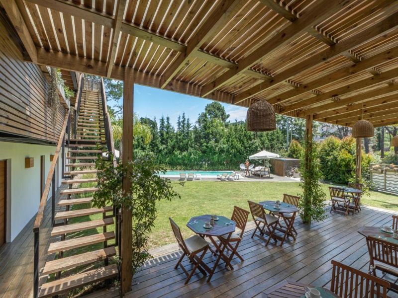 Hospedagem Live Hotel Boutique, com mesas, piscina e vegetação ao redor