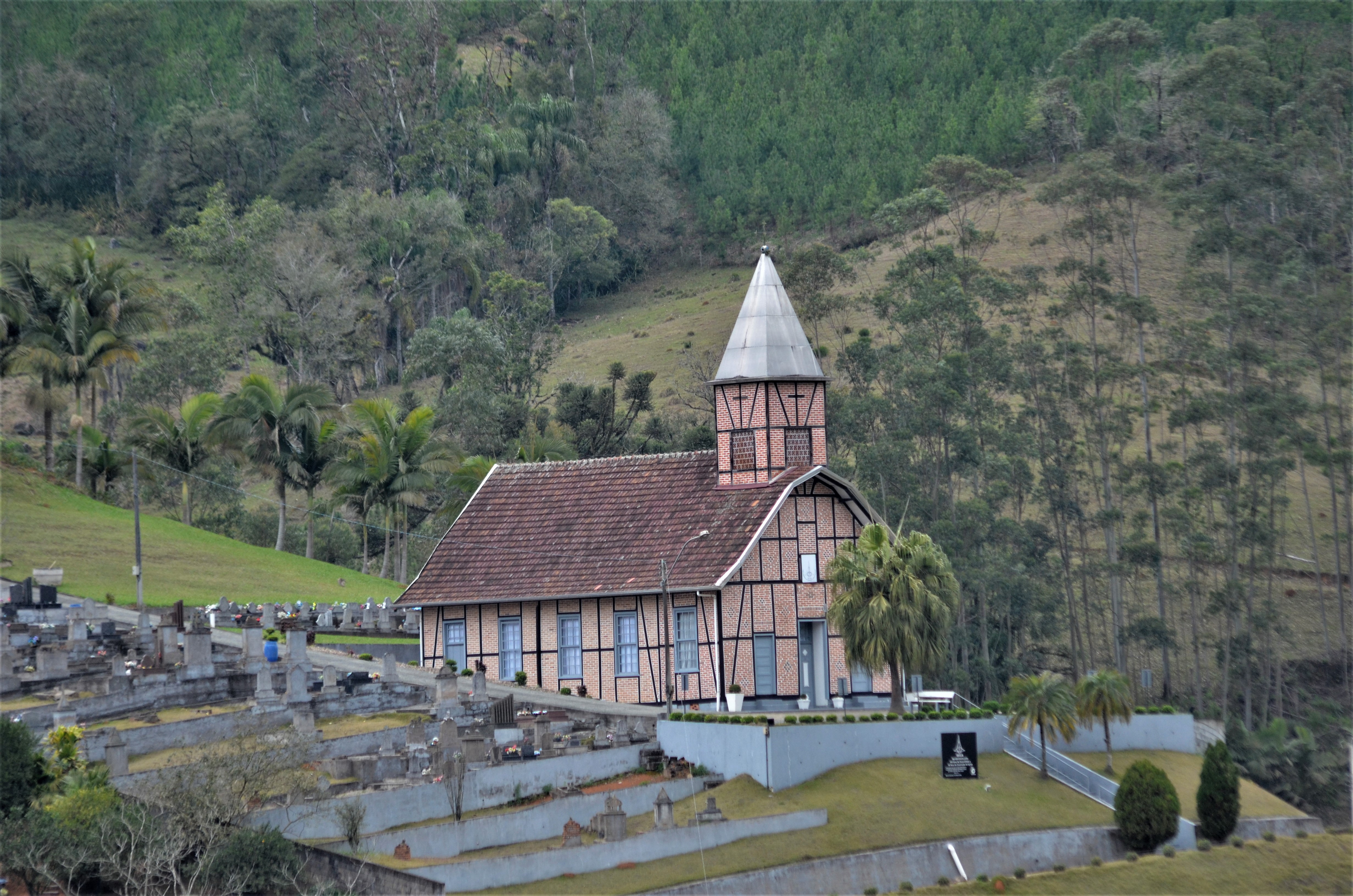 Igreja é rodeada por vegetação, no alto de uma colina