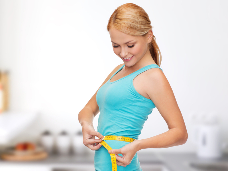 Circunferência abdominal é diferente entre homens e mulheres Mulher medindo a cintura