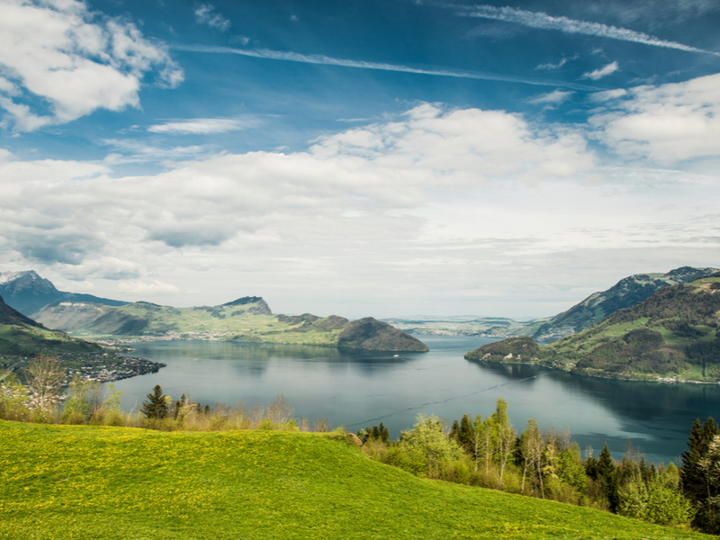Lago dos Quatro Cantões com céu azul e montanhas de fundo